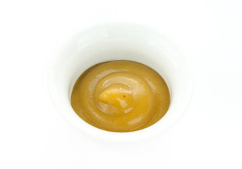 Mustard sauce in white bowl isolated on white background