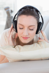 Close up of a relaxed casual woman enjoying music on sofa