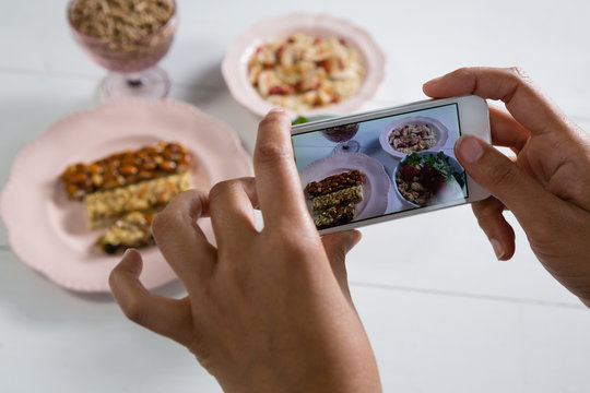 Hands taking photo of breakfast with mobile phone