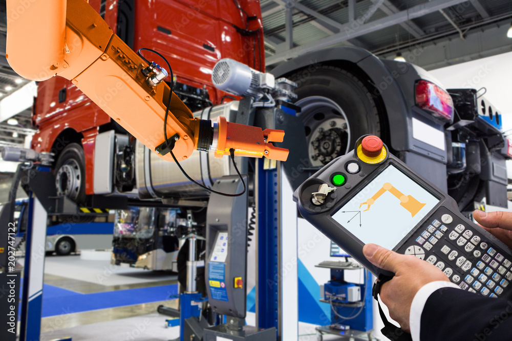 Leinwandbilder Engineer with teach pendant device. Programming robot with robotic arm at a car service or assembly line