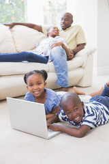 Obraz premium Happy siblings using their laptop