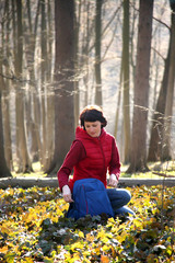 Beautiful young woman bathes in the rays of spring sun in a clearing in the forest. Beautiful woman posing for the camera in a spring forest.