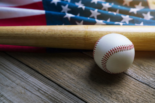 baseball and baseball bat with American flag in the background