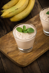 Chocolate banana smoothie in a glass on wood


