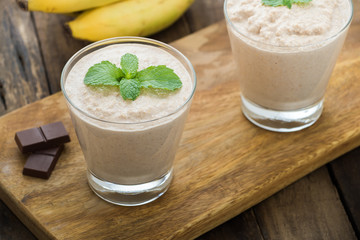 Chocolate banana smoothie in a glass on wood

