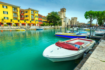 Fototapeta na wymiar Motorboats in harbor of Sirmione, Lombardy, Italy, Europe