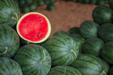 Many big sweet green watermelons and one cut watermelon