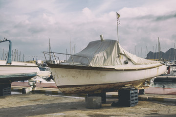 The old ship is under repair in a dry dock.