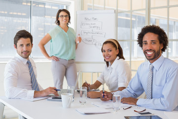 Businesswoman giving presentation to colleagues in office