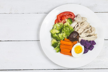 Boiled chicken breasts and vegetables with sports and diet concepts.