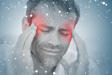 Composite image of man having a headache against snow
