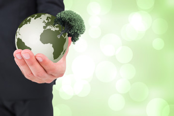 Businessman holding out his hand against green abstract light spot design