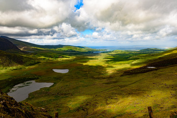 Wide, panoramic view from the point located high in the mountains. Ocean is visible in the far background