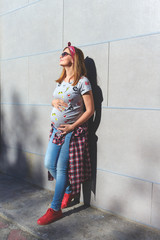 Beautiful stylish woman expecting baby having rest outdoors. Pregnancy, maternity and happiness concept. Copy space.