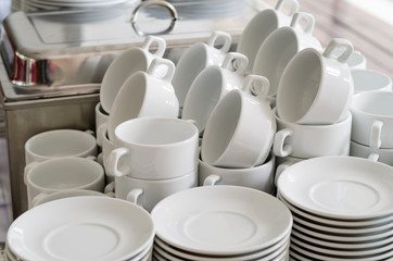 Stack of white porcelain cups and plates