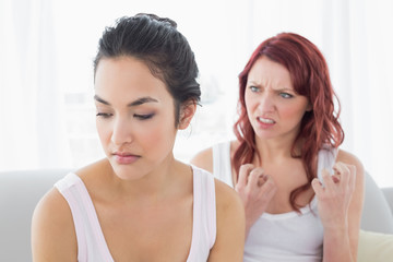Angry female friends having an argument in living room
