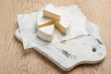 Camembert cheese, on a wooden texture