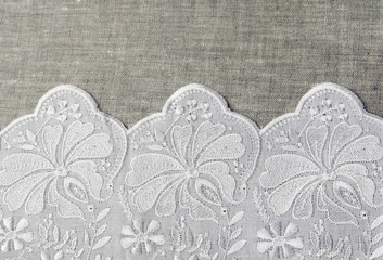 white lace with embroidery napkin on a gray tablecloth

