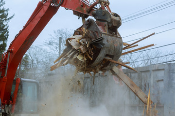 old house being demolished by a large backhoe