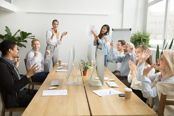 Corporate diverse team colleagues congratulating motivated african coworker with business success...