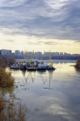 Ice drift on the Irtysh river in Siberia. Technical and transport vessels parked in the backwater