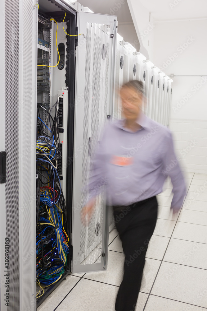 Poster technician walking next to a data store