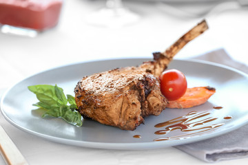 Plate with delicious rib and vegetables on table, close up