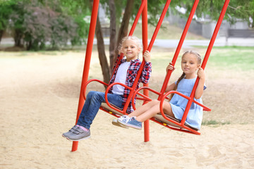 Cute girls on swings at playground