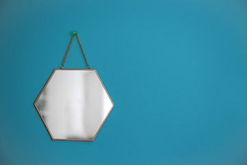 Mirror hanging on empty color wall