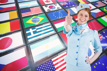 Pretty air hostess with hand on hip against screen collage showing international flags