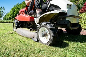 Obraz premium Gartenarbeit - Rasenpflege, Aufsitzmäher im Einsatz