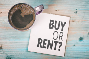 Buy or rent concept on a napkin with cup of espresso coffee