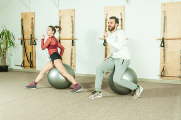 Obraz premium Young beautiful fitness couple workout acrobatic exercise with dancing on the ball as preparation for the competition, selective focus