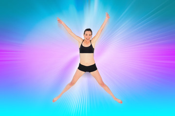 Fototapeta na wymiar Full length of a sporty young woman jumping against abstract background