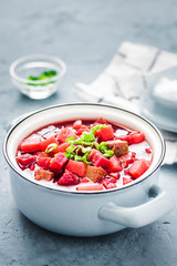 Borscht, traditional beetroot soup in pot on light blue,concrete background. Selective focus, space for text.