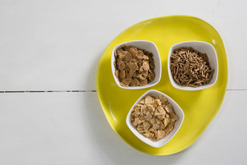 Wheat flakes and cereal bran sticks in bowl
