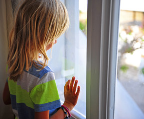 Little boy looking at window