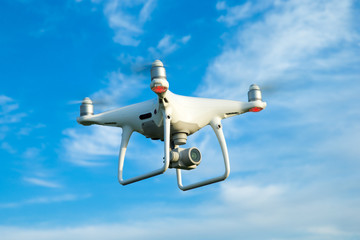 Naklejka na ściany i meble drone hovering in a bright blue sky. New technology in the aero photo shooting.