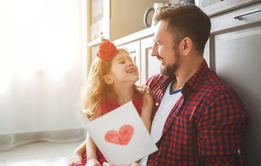 Father's day. Happy family daughter giving dad greeting card
