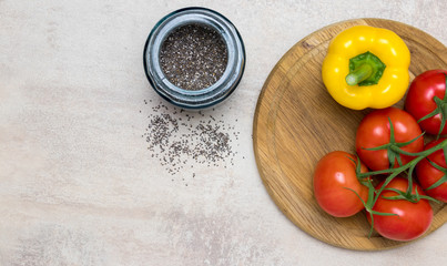 Tomatoes and yellow pepper on wood.