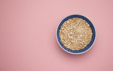 A bowl of oatmeal on a pink background.