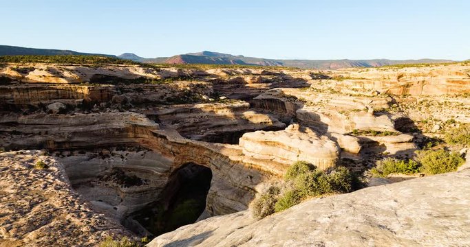 timelapse of sunset at natural bridges national monument showing clouds and shadows moving across the landscape and shadows growing across the natural arch