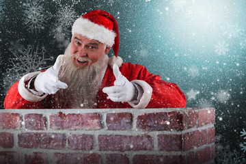 Portrait of happy Santa Claus making hand gesture over wall against snowflake pattern