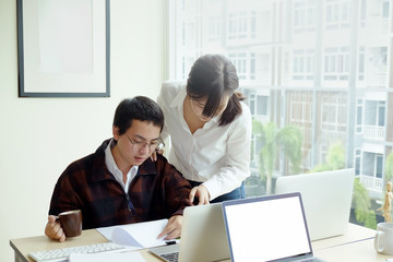 Obraz premium Two Business colleagues standing around boardroom table having informal discussion a new start up project.