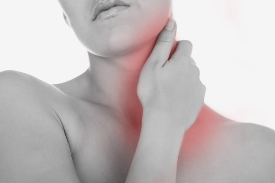 Woman massaging neck against white background