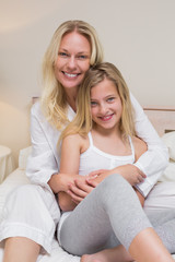 Obraz premium Mother and daughter sitting in bed