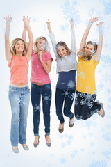 Obraz premium Smiling celebrating girls jumping up against snow falling