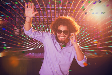 Male DJ playing music against flying colours