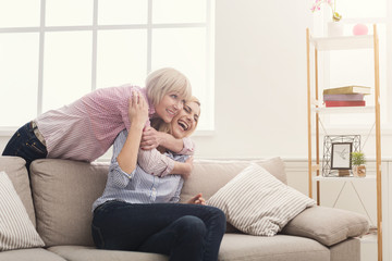 Happy adult mother and daughter embracing at home