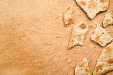 Cracker crumbs on wooden tray.